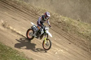 Motocross rider descending a dirt track in protective gear