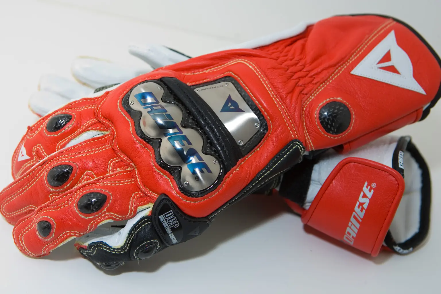 Red and white Dainese motorcycle racing gloves