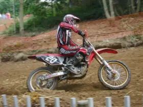 Off-road rider wearing motocross clothing and boots on a dirt track