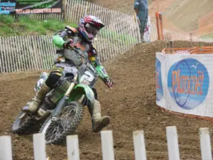 Motocross rider wearing protective off-road clothing on a dirt circuit