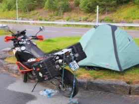 Motorcycle touring luggage beside a small campsite