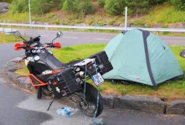 Motorcycle touring luggage beside a small campsite