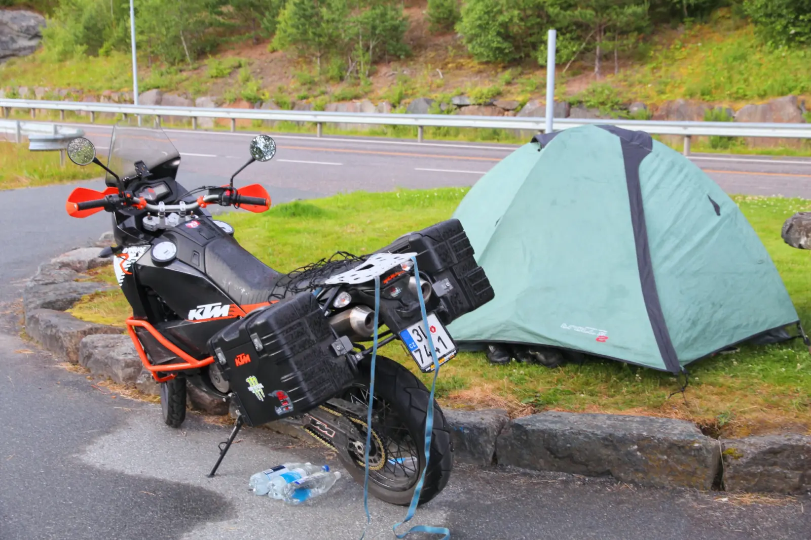 Motorcycle touring luggage beside a small campsite