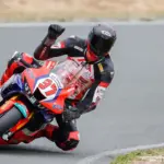 Motorcycle racer leaning through a bend in protective racing leathers
