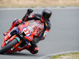 Motorcycle racer leaning through a bend in protective racing leathers