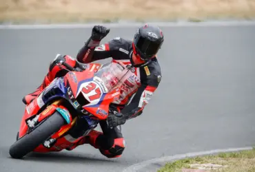 Motorcycle racer leaning through a bend in protective racing leathers