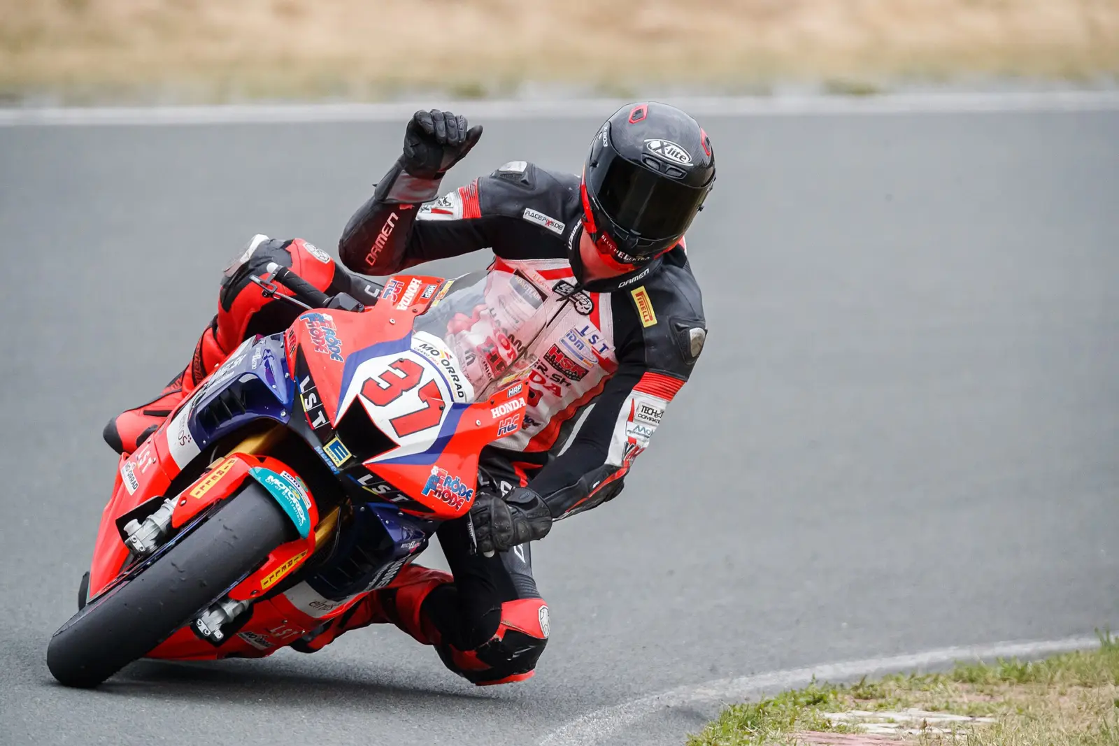 Motorcycle racer leaning through a bend in protective racing leathers