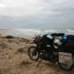 Touring motorcycle carrying luggage beside a coast
