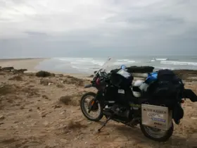 Touring motorcycle carrying luggage beside a coast