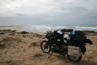 Touring motorcycle carrying luggage beside a coast