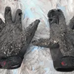 Worn motorcycle gloves showing damage and signs of use