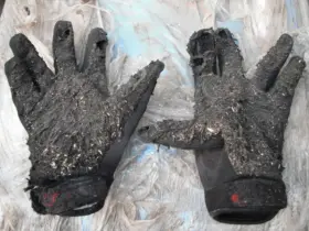 Worn motorcycle gloves showing damage and signs of use