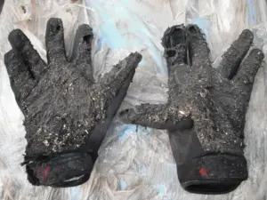 Worn motorcycle gloves showing damage and signs of use
