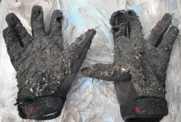 Worn motorcycle gloves showing damage and signs of use