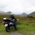 Helmeted touring rider on a motorcycle in a mountainous landscape