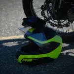 Off-road motorcycle helmet resting beside a motorcycle wheel