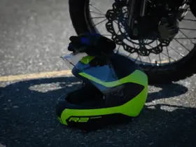 Off-road motorcycle helmet resting beside a motorcycle wheel