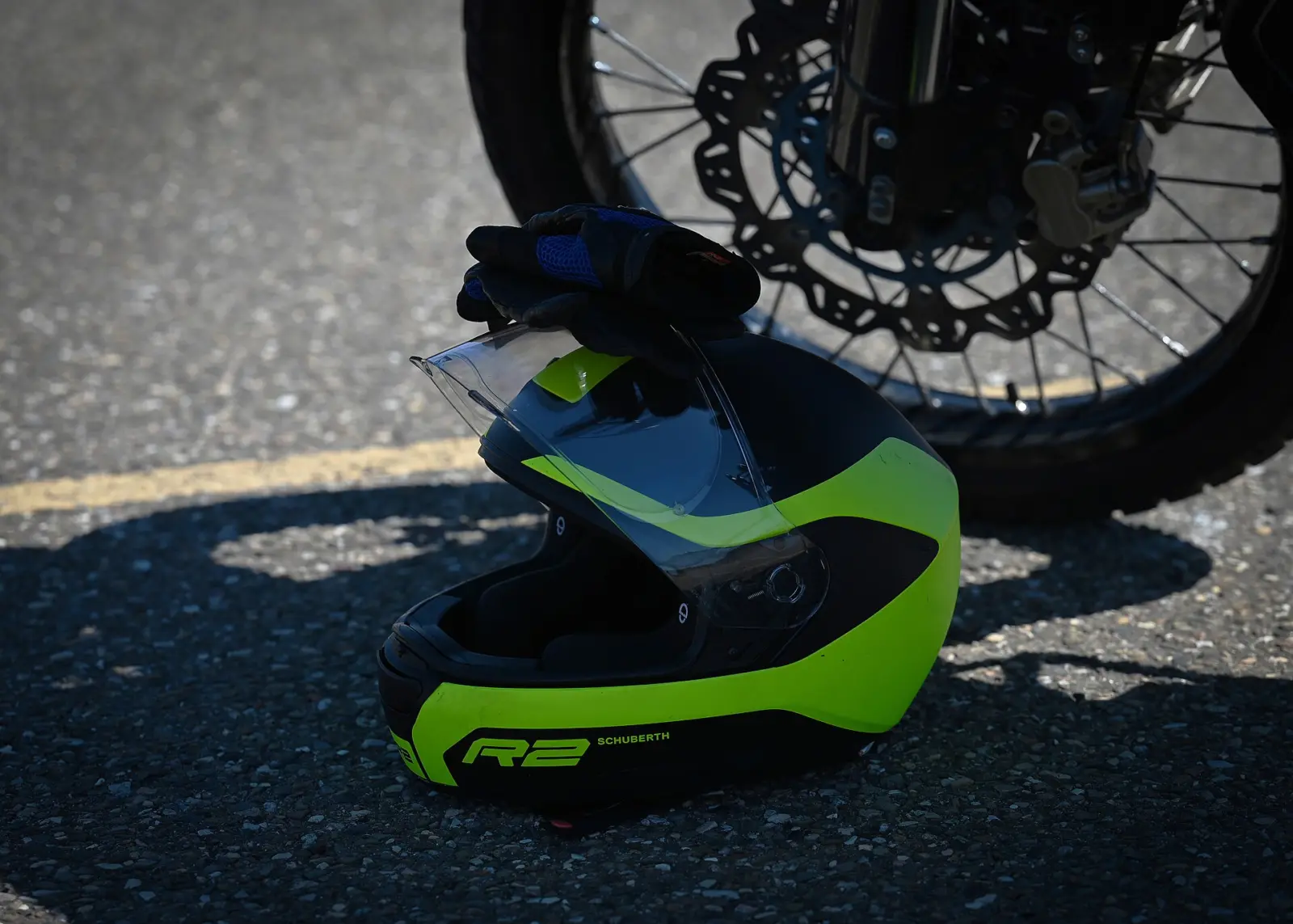 Off-road motorcycle helmet resting beside a motorcycle wheel