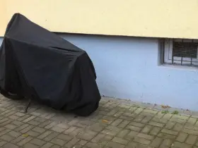Parked motorcycle protected by a full outdoor cover