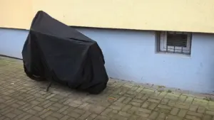 Parked motorcycle protected by a full outdoor cover