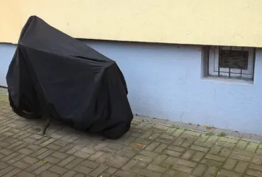 Parked motorcycle protected by a full outdoor cover