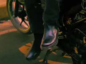 Rider’s boots resting beside a motorcycle footrest