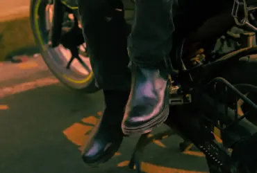 Rider’s boots resting beside a motorcycle footrest