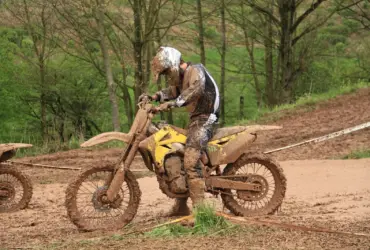 Motocross rider wearing boots, gloves and protective riding clothing