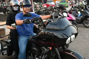 Motorcyclists with helmets and sunglasses beside a touring motorcycle