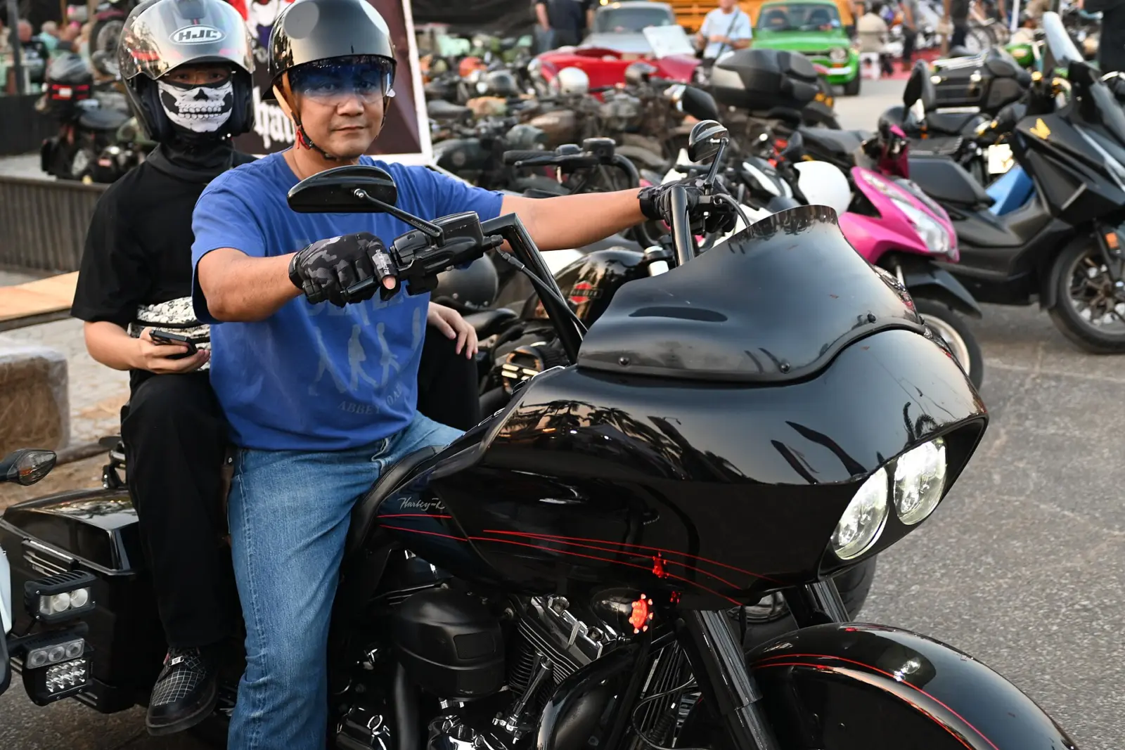 Motorcyclists with helmets and sunglasses beside a touring motorcycle
