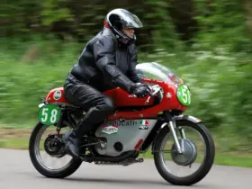 Motorcyclist wearing black leather riding equipment on a red Ducati