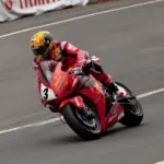 Motorcycle racer in red protective leathers on a racing circuit