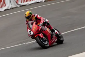 Motorcycle racer in red protective leathers on a racing circuit