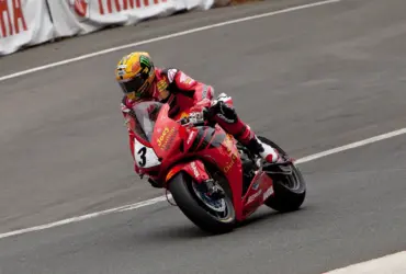 Motorcycle racer in red protective leathers on a racing circuit