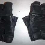 Pair of black short motorcycle gloves on a light background