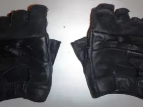 Pair of black short motorcycle gloves on a light background