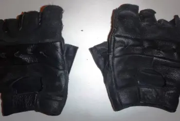 Pair of black short motorcycle gloves on a light background