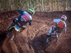 Motocross racers wearing helmets and protective clothing on a dirt track
