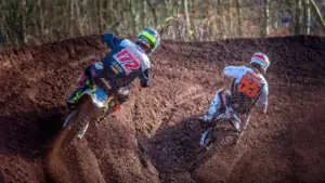 Motocross racers wearing helmets and protective clothing on a dirt track