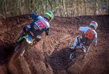 Motocross racers wearing helmets and protective clothing on a dirt track