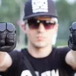 Motorcyclist holding up a pair of black protective gloves