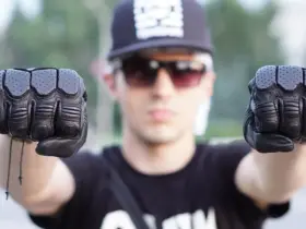 Motorcyclist holding up a pair of black protective gloves