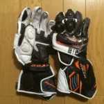 Black and white motorcycle racing gloves shown palm-side up