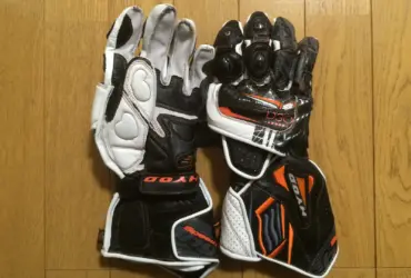 Black and white motorcycle racing gloves shown palm-side up