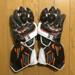 Pair of black, white and orange motorcycle racing gloves