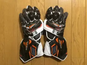 Pair of black, white and orange motorcycle racing gloves