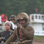 Motocross rider wearing a helmet and mud-covered goggles