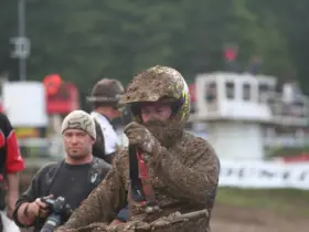 Motocross rider wearing a helmet and mud-covered goggles