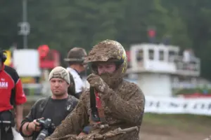 Motocross rider wearing a helmet and mud-covered goggles