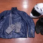Motorcycle helmet, leather jacket, gloves and boots arranged together